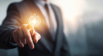 Businessman hand pointing to activate a glowing power on/off symbol. Concept of start, new beginnings, technology, and digital energy on a virtual interface