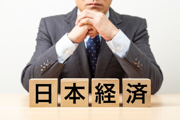 「日本経済」と書かれたブロックとビジネスマン