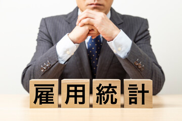 「雇用統計」と書かれたブロックとビジネスマン