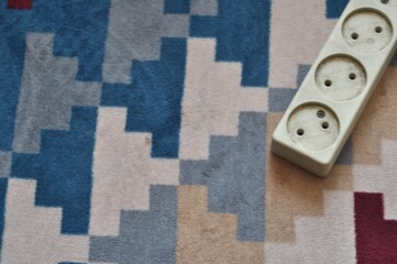 Electrical Power Strip on Patterned Carpet Background with Copy Space