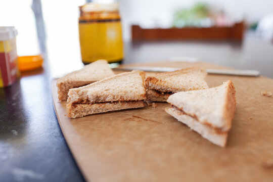 Vegemite sandwich triangles on cutting board on kitchen bench in Australia ready for morning tea