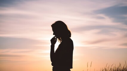 Silhouetted figure of a person deep in thought against a vibrant, dusky sky