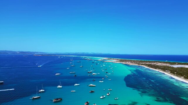 speed ramp hyper motion time lapse of many pleasure boats anchored in the clear turquoise waters of Formentera Balearic island. Magic aerial view fly reverse panorama overview drone