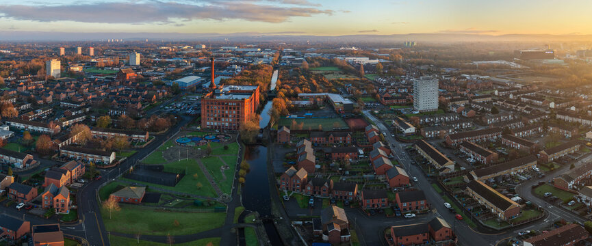 Aerial image of Victoria Mill and the Miles Platting Canal-Side Village at Sunrise in Manchester. 