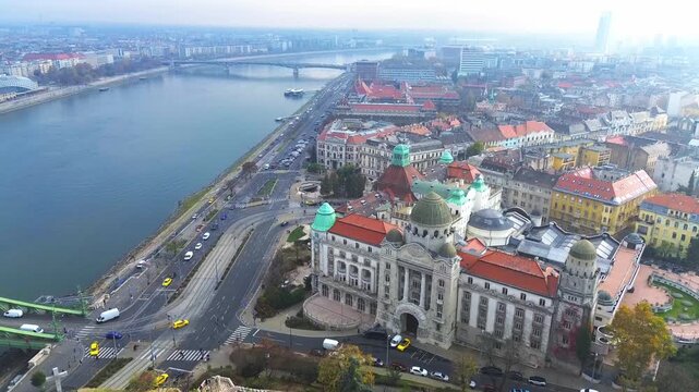 Aerial view of the iconic Gell&eacute;rt Hotel and Thermal Baths on the banks of the Danube River in Budapest, Hungary, highlighting historic urban architecture and city life.