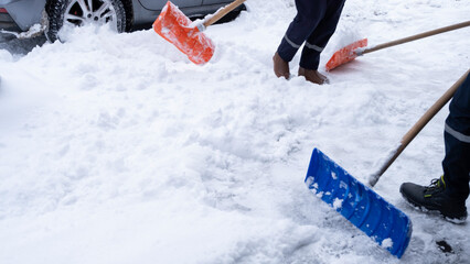 Municipal workers are cleaning the sidewalks blocked by snow. snow removal workers with snow shovels © MahmutSonmez
