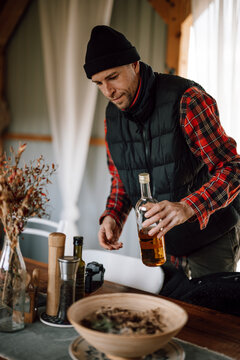Man prepares meal with bottle and ingredients