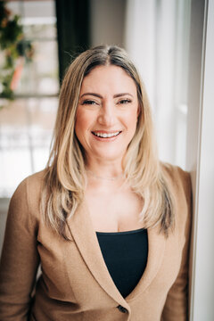 Woman smiling in business blazer portrait indoors