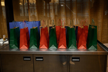 Colorful New Year gift bags with festive wrapping, bright decorations and holiday presents, cheerful seasonal celebration atmosphere.