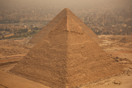Aerial view of the iconic Great Pyramid of Giza standing majestically against the backdrop of the sprawling cityscape, Cairo, Egypt.