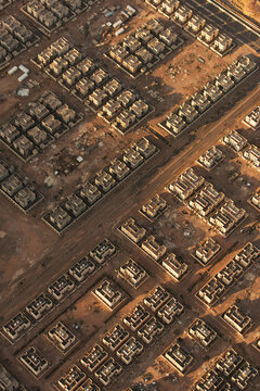 Aerial view of symmetrical, low-rise buildings casting shadows on the arid landscape, creating a mesmerizing geometric pattern, Madinah, Al Madinah Province, Saudi Arabia.