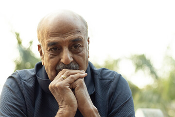 Portrait of a Indian sad, depression, thinking, Upset lonely homeless senior man in garden sitting...
