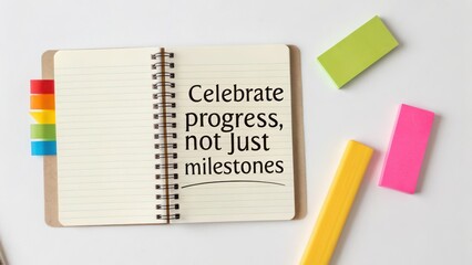 Open notebook with text celebrating progress on white background