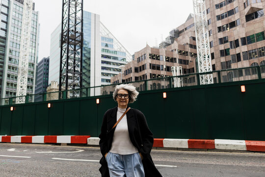 Fashionable mature woman with grey hair walking in urban London city