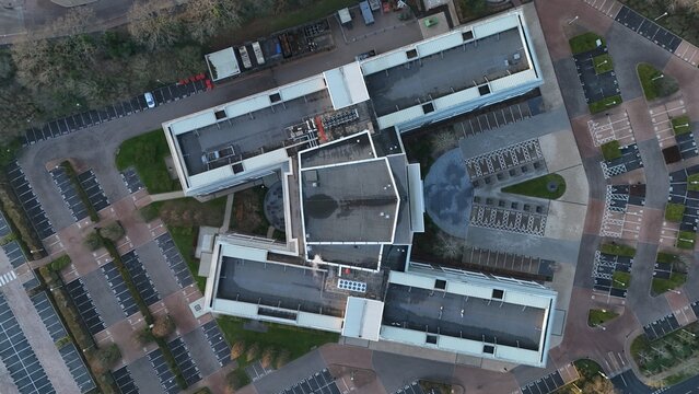 Aerial view of the symmetrical architecture of a building complex with a circular design element and surrounding parking lots, Solihull, England, United Kingdom.