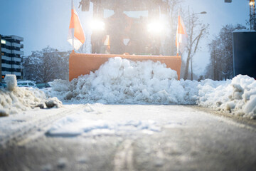 Snowplow clearing street during winter blizzard conditions