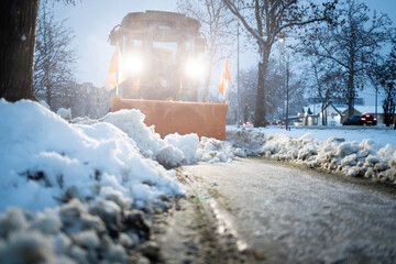 Snowplow clearing street during winter blizzard conditions