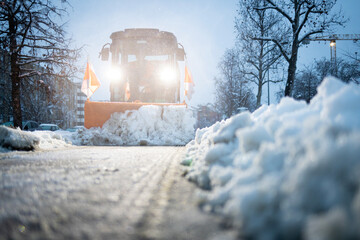 Snow plow clearing snow from winter city street