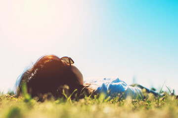 Person Lying on Grass and Looking at Clear Sky in Bright Daylight