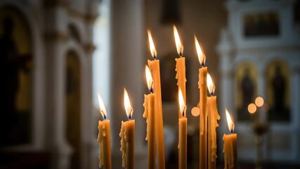 Golden church candles burning with smoke in a spiritual setting. Lit wax candle flames in a temple for prayer and worship.