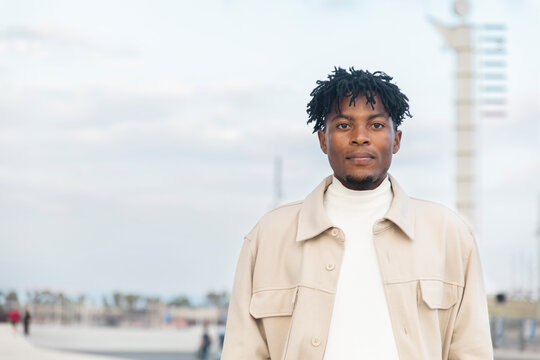 Confident young man in casual jacket outdoors with calm expression