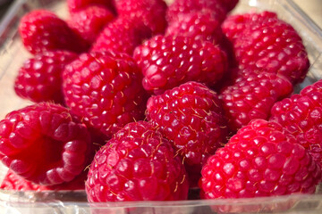 Fresh Ripe Raspberries in a Plastic Container for Summer Meals and Recipes