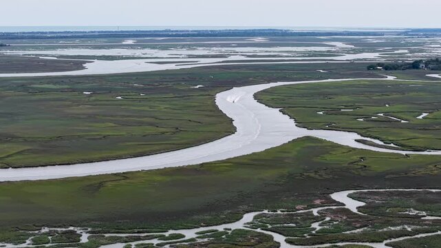 Aerial drone footage showing a winding river snaking through green marshlands and wetlands at Middleton Place Plantation near Charleston, South Carolina.