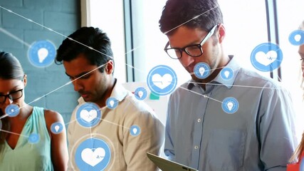 Animation of connected heart pulse and lightbulb icons over diverse coworkers using technology - Powered by Adobe