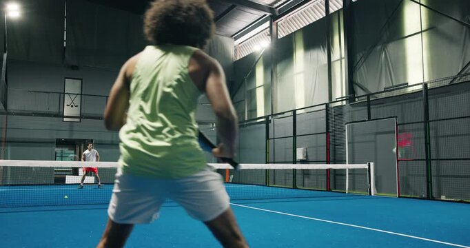 Back, men and playing padel on court for fitness contest, exercise and swing technique for match. Athlete, people and hitting ball with racket for sports game, tennis competition and tournament event