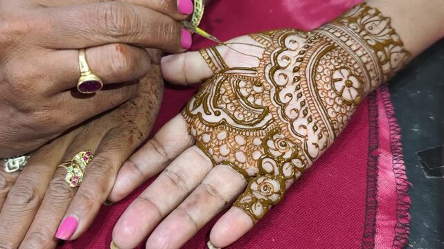 Mehndi artist making mehndi bridal hand In India, mehndi design.