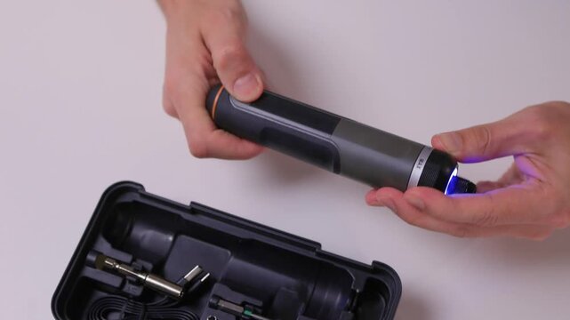Instructional scene of assembling electric screwdriver bits carefully, Closeup of repair activity involving selecting and installing screwdriver bits on clean table