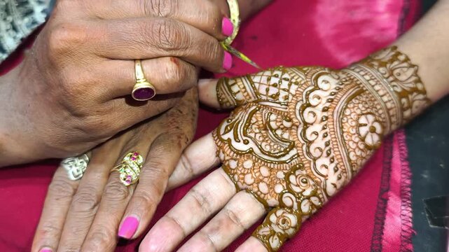 Mehndi artist making mehndi bridal hand In India, mehndi design.