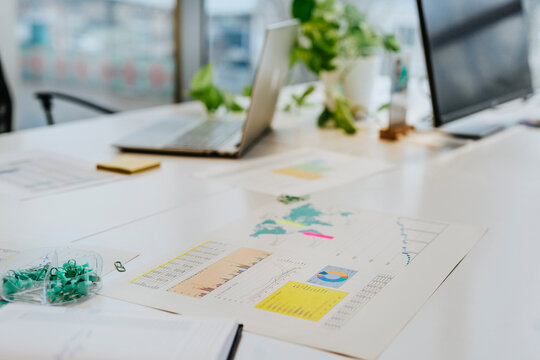 Business analysis charts and documents on office desk with no people