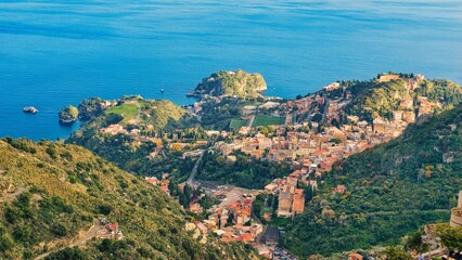 Obraz premium Castelmola, Italy - December 13, 2025: stunning panoramic view from Castelmola, Sicily, Italy. In the square below some people are walking and enjoying the tranquil atmosphere. Just before sunset.