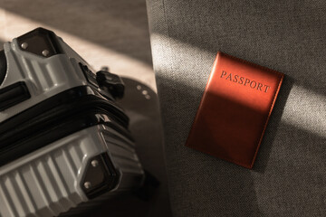 Leather passport on sofa with modern suitcase in natural light