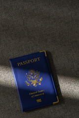 United States passport resting on neutral fabric with soft sunlight and shadow
