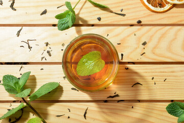 Green tea in the center of wooden table with leaves