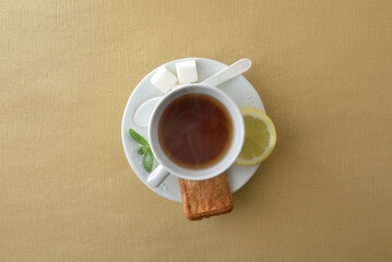 Teacup with ingredients isolated in the center on brown tablecloth