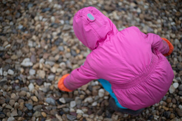 The child collects stones. Child looking for a beautiful stone. Walk in the park.