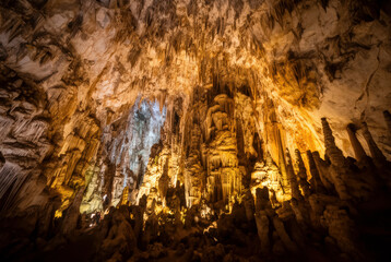 A breathtaking cave interior with illuminated stalactites and stalagmites creating an otherworldly atmosphere. Perfect for projects needing natural beauty or dramatic backgrounds.