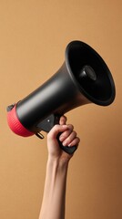 Hand holding black megaphone on brown background, vertical photo