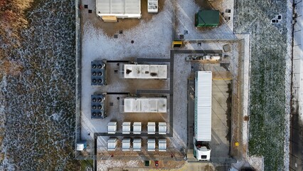 Aerial view of container units, a truck, and other structures in a snow dusted environment, Corby, England, United Kingdom.