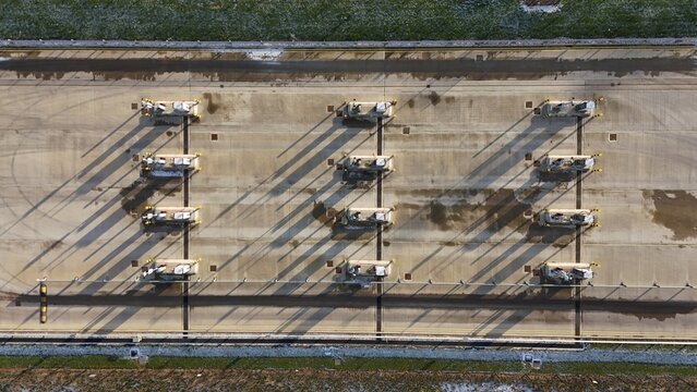 Aerial view of the stark concrete landscape dotted with evenly spaced structures casting long shadows under the winter sun, Corby, England, United Kingdom.