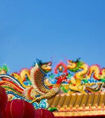 Close-up of Colorful Phoenix Mosaic Art on Traditional Chinese Shrine Roof.