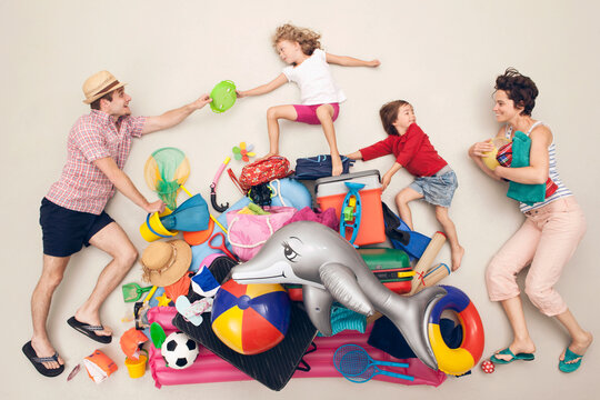 Family with luggage and beach toys playing in summer holiday studio setup