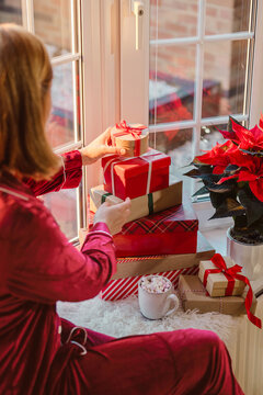 Cozy Christmas morning with gifts and poinsettia on windowsill
