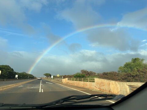 Rainbow Over Straight Road Seen Through Car Windshield in Hawaii