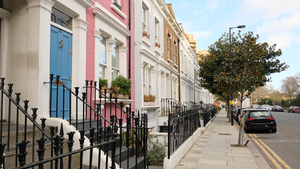 Typical Victorian terraced houses in England. Exterior view of cozy residential buildings in London with metal fence, several floors, windows and front door with molding. Real estate, Living apartment