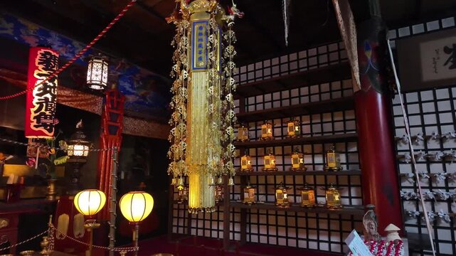 Lit interior of Japanese temple with lanterns and traditional decor