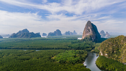 Aerial view of emerald forests meet towering limestone karsts in the serene waters of Phang Nga Bay, Phang Nga Bay, Thailand.